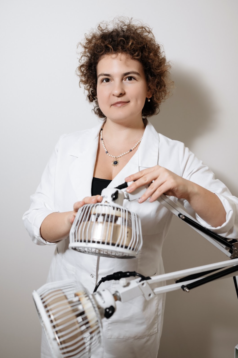 Helena Olearska w białym fartuchu lekarskim przy lampie zabiegowej